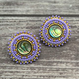 Handmade drop earrings with abalone shell button, seed beads, 24kt gold beads, hide backing, and 925 silver studs, 1 inch long.