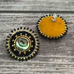 Handmade drop earrings with abalone shell button, seed beads, 24kt gold beads, hide backing, and 925 silver studs, 1 inch long.