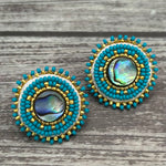 Handmade drop earrings with abalone shell button, seed beads, 24kt gold beads, hide backing, and 925 silver studs, 1 inch long.