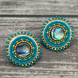 Handmade drop earrings with abalone shell button, seed beads, 24kt gold beads, hide backing, and 925 silver studs, 1 inch long.