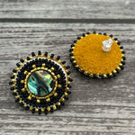 Handmade drop earrings with abalone shell button, seed beads, 24kt gold beads, hide backing, and 925 silver studs, 1 inch long.