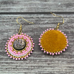Handmade drop earrings with abalone shell button, seed beads, 24kt gold beads, hide backing, and 18kt gold hooks, 2” long.