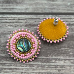 Handmade drop earrings with abalone shell button, seed beads, 24kt gold beads, hide backing, and 925 silver studs, 1 inch long.