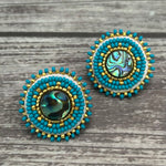 Handmade drop earrings with abalone shell button, seed beads, 24kt gold beads, hide backing, and 925 silver studs, 1 inch long.