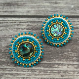 Handmade drop earrings with abalone shell button, seed beads, 24kt gold beads, hide backing, and 925 silver studs, 1 inch long.