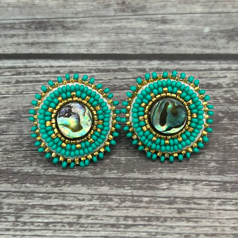 Handmade drop earrings with abalone shell button, seed beads, 24kt gold beads, hide backing, and 925 silver studs, 1 inch long.