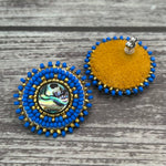 Handmade drop earrings with abalone shell button, seed beads, 24kt gold beads, hide backing, and 925 silver studs, 1 inch long.