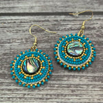 Handmade drop earrings with abalone shell button, seed beads, 24kt gold beads, hide backing, and 18kt gold hooks, 2” long.