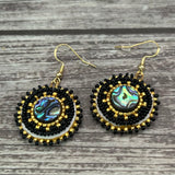 Handmade drop earrings with abalone shell button, seed beads, 24kt gold beads, hide backing, and 18kt gold hooks, 2” long.