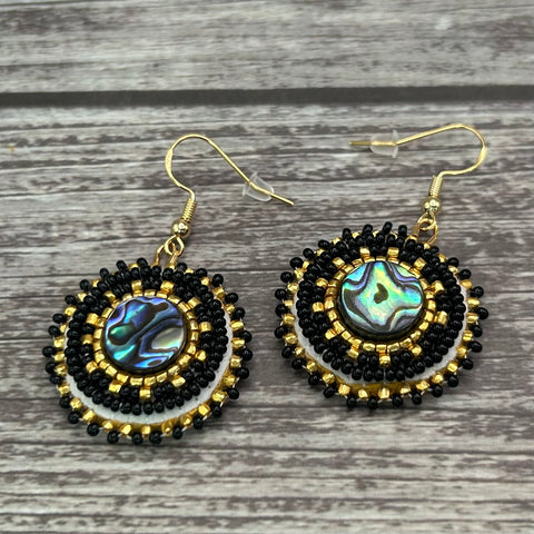 Handmade drop earrings with abalone shell button, seed beads, 24kt gold beads, hide backing, and 18kt gold hooks, 2” long.