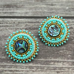 Handmade drop earrings with abalone shell button, seed beads, 24kt gold beads, hide backing, and 925 silver studs, 1 inch long.