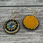 Handmade drop earrings with abalone shell button, seed beads, 24kt gold beads, hide backing, and 18kt gold hooks, 2” long.